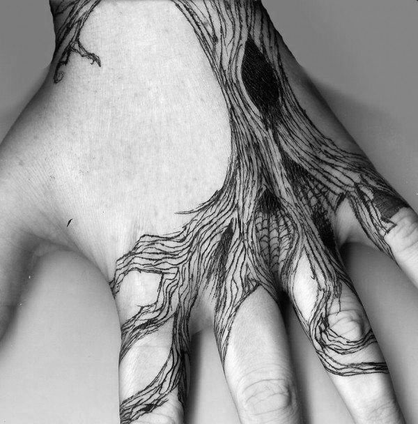 a person's hand with an intricate tree tattoo on the middle of their palm