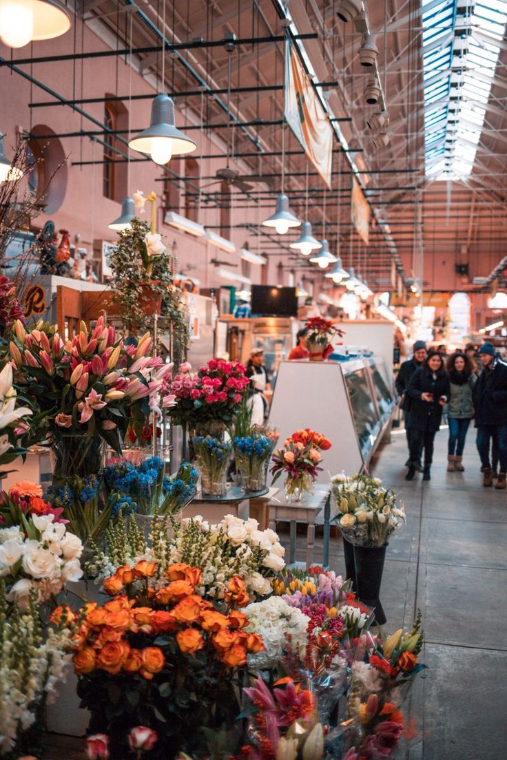 an indoor market with lots of flowers on display