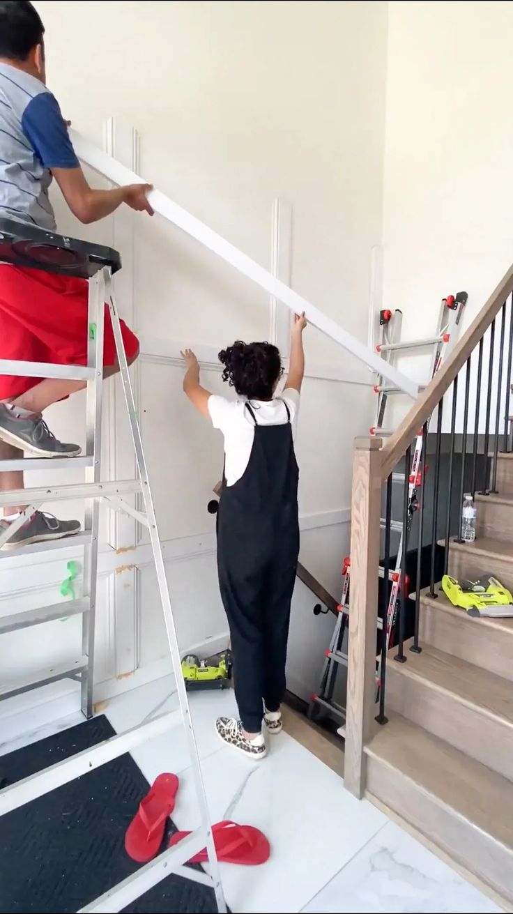 two people are climbing up the stairs with their arms in the air and one person is holding on to the handrail