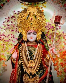 an idol is displayed in front of flowers