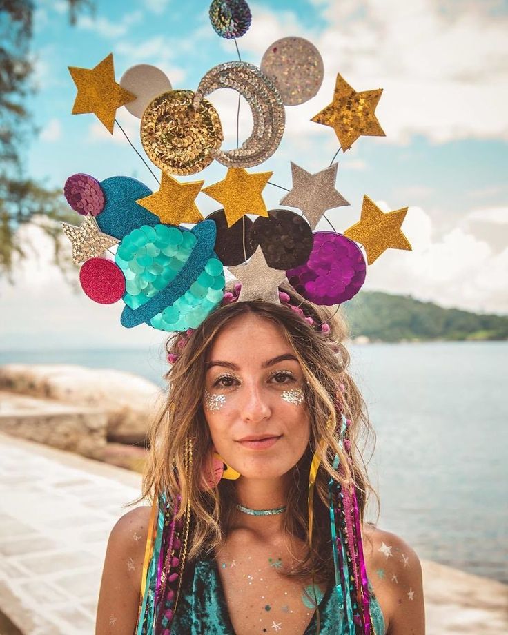 a young woman with long hair wearing a head piece made out of stars and circles