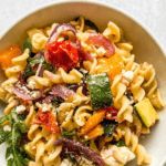 a white bowl filled with pasta salad on top of a table