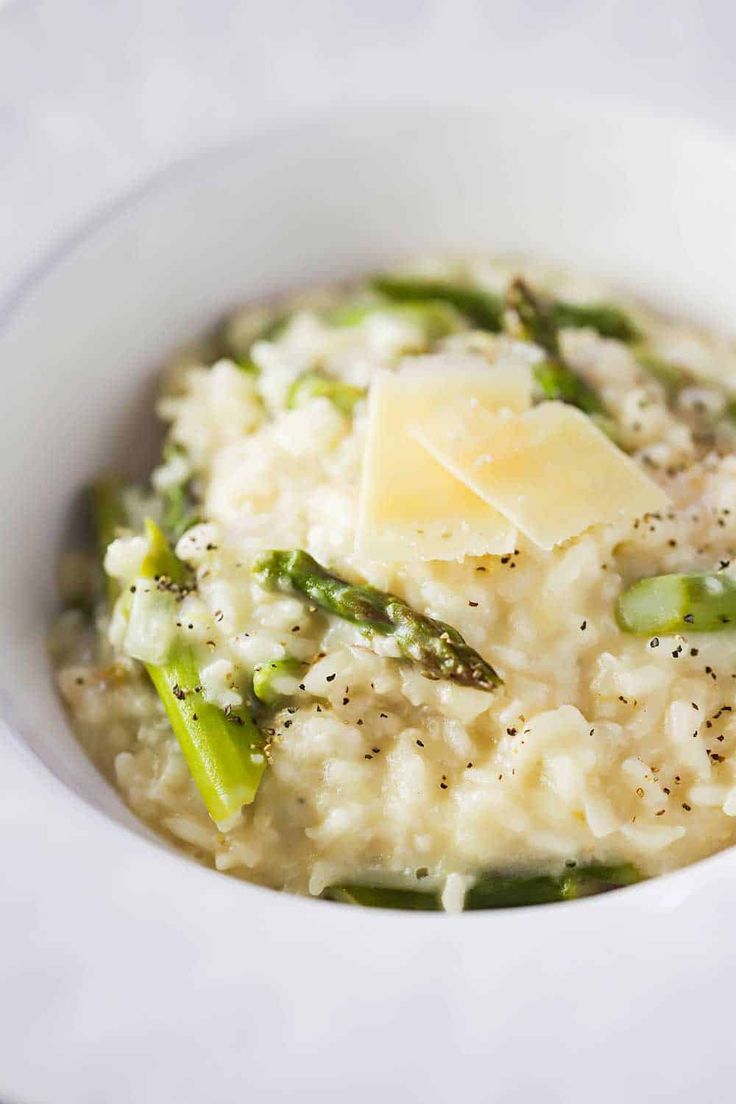 a white bowl filled with rice and asparagus