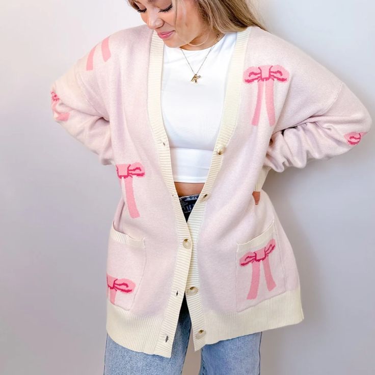 Stay Cozy And Chic With Our Oversized Bow Cardigan. Crafted From Soft, Luxurious Knit Fabric, This Cardigan Features An Effortlessly Elegant Bow Design Throughout , Adding A Touch Of Femininity To Your Look. With Its Relaxed Fit And Versatile Style, It's Perfect For Layering Over Your Favorite Tops For A Polished Yet Comfortable Ensemble. Whether You're Lounging At Home Or Stepping Out For A Casual Outing, This Cardigan Is Sure To Keep You Stylishly Snug All Day Long. Features - Front Buttons - Cozy Pink V-neck Outerwear, Pink V-neck Cardigan For Loungewear, Chic Oversized Pink Sweater, Feminine Sweater For Winter Day Out, Cute Pink V-neck Outerwear, Feminine Winter Sweater For Day Out, Feminine Sweater For Day Out In Winter, Casual Pink Long Sleeve Cardigan, Casual Long Sleeve Pink Cardigan