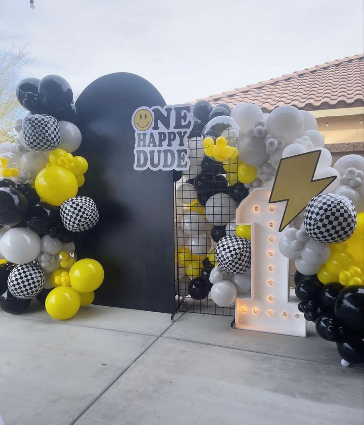 some balloons are on the side of a building with a sign that says one happy dude