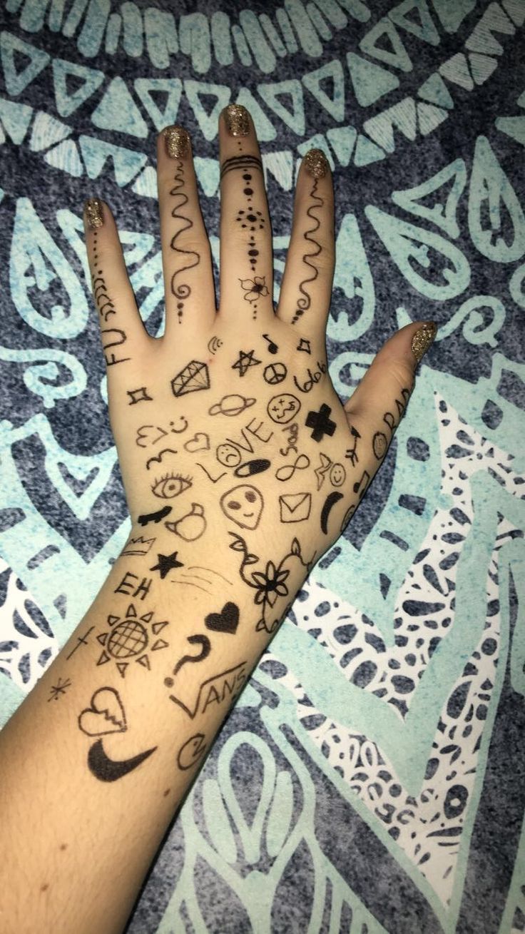 a person's hand with tattoos on it and writing all over the palm area