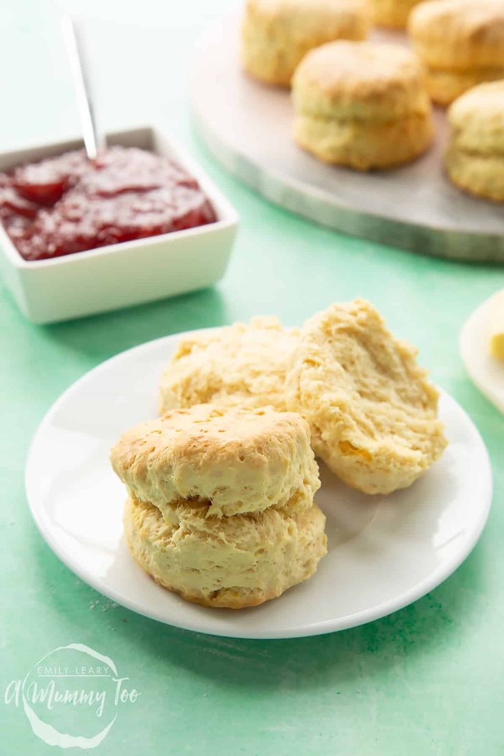 biscuits and jam are sitting on plates next to each other