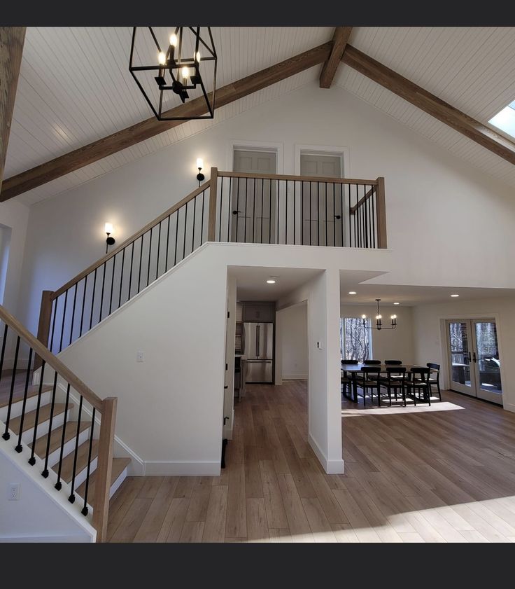 a large open floor plan with stairs leading up to the second story and dining room