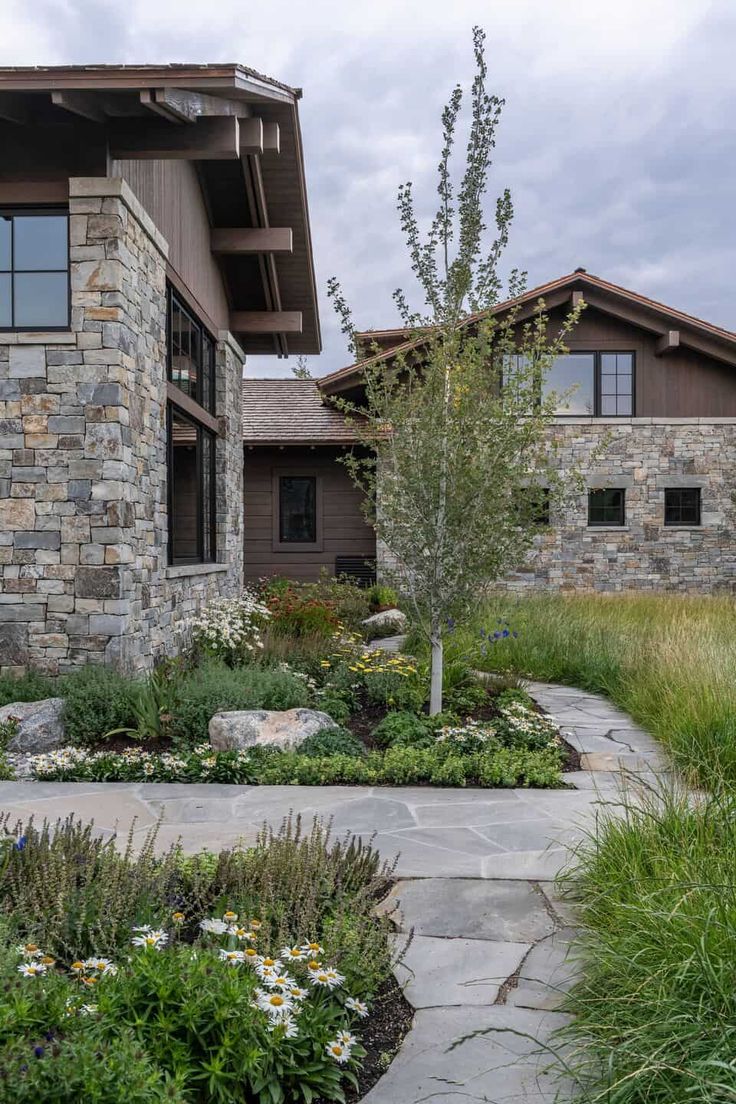 a stone house with landscaping around it