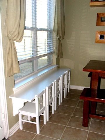 a room with a table, bench and window sill in front of the door