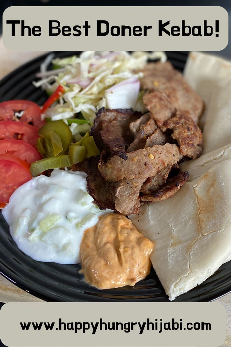 a black plate topped with meat, vegetables and pita bread next to kebab sauce