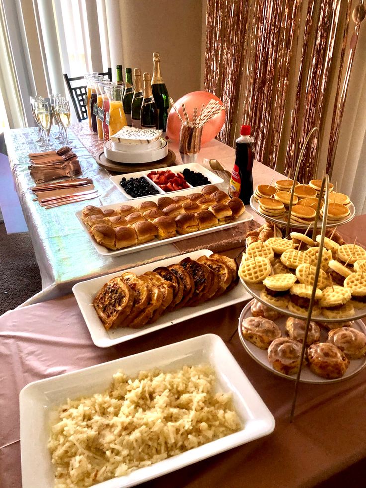 an assortment of pastries and desserts displayed on serving trays at a party