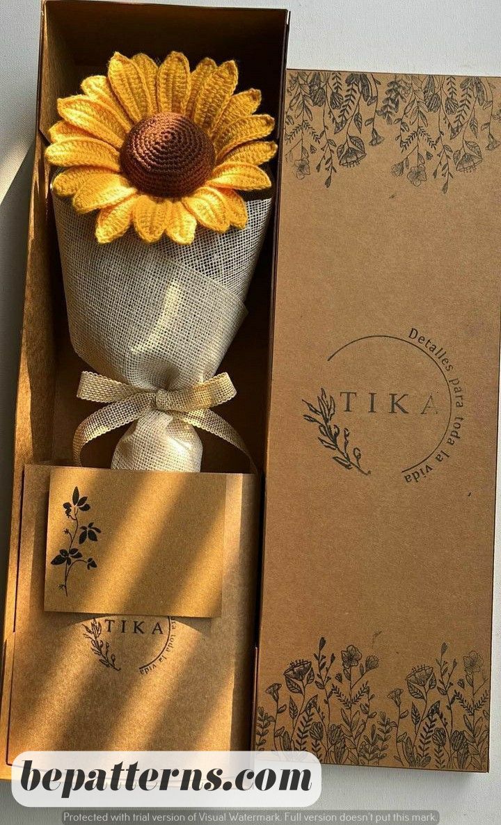 a sunflower in a gift box next to an envelope