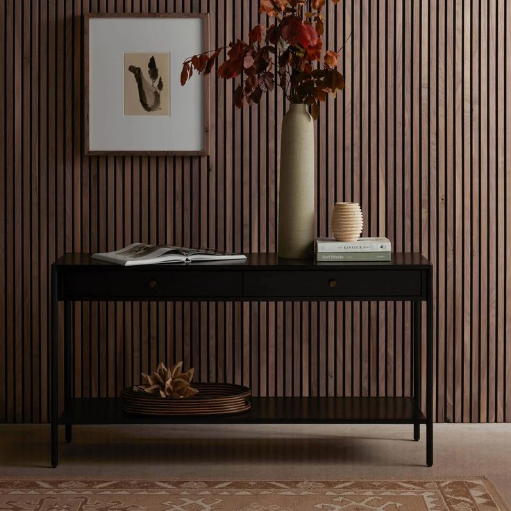 a vase with flowers on top of a table in front of a striped wallpaper