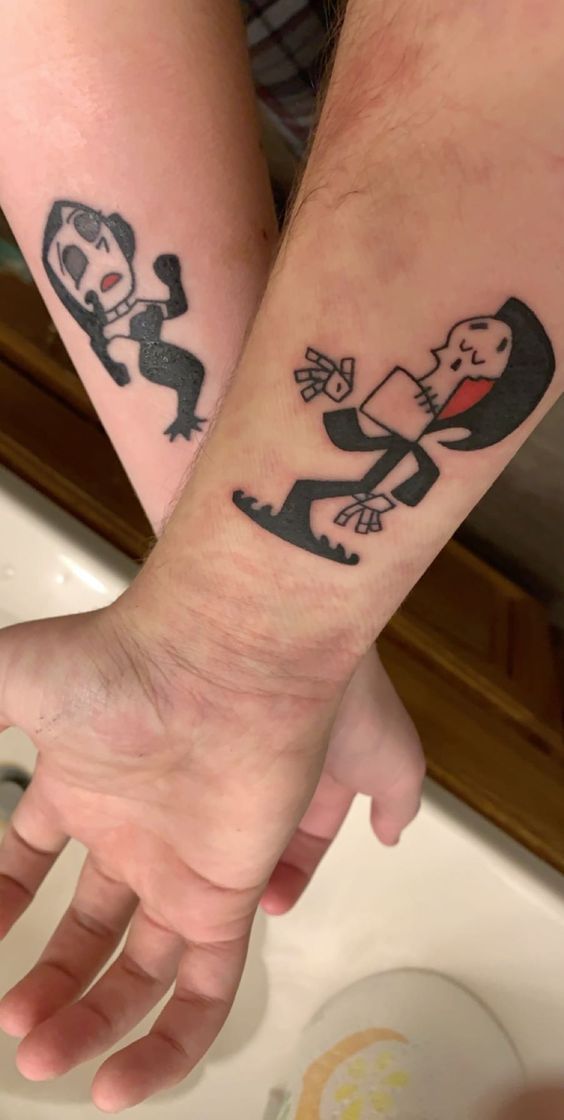 two people holding hands with tattoos on them