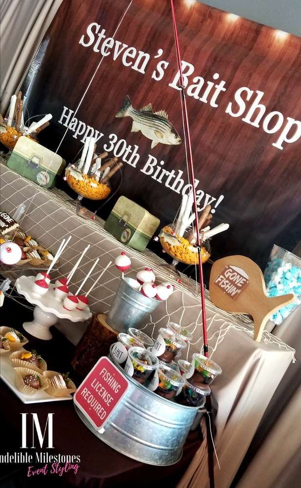 an assortment of items displayed in buckets on a table at a fishing themed birthday party