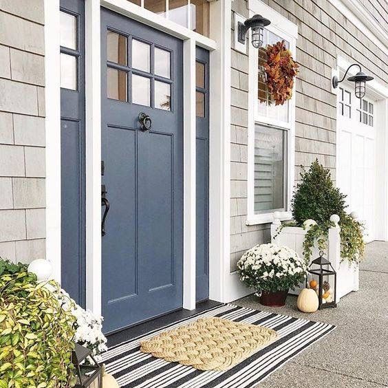 a blue front door on a gray house