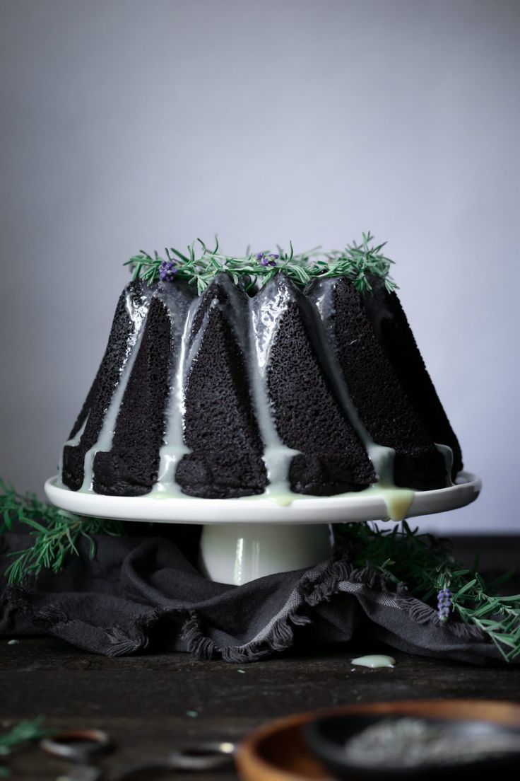 a chocolate cake with white frosting and sprigs on top