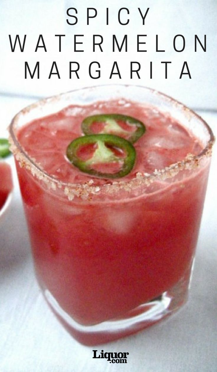 a close up of a drink in a glass with the words spicy watermelon margarita