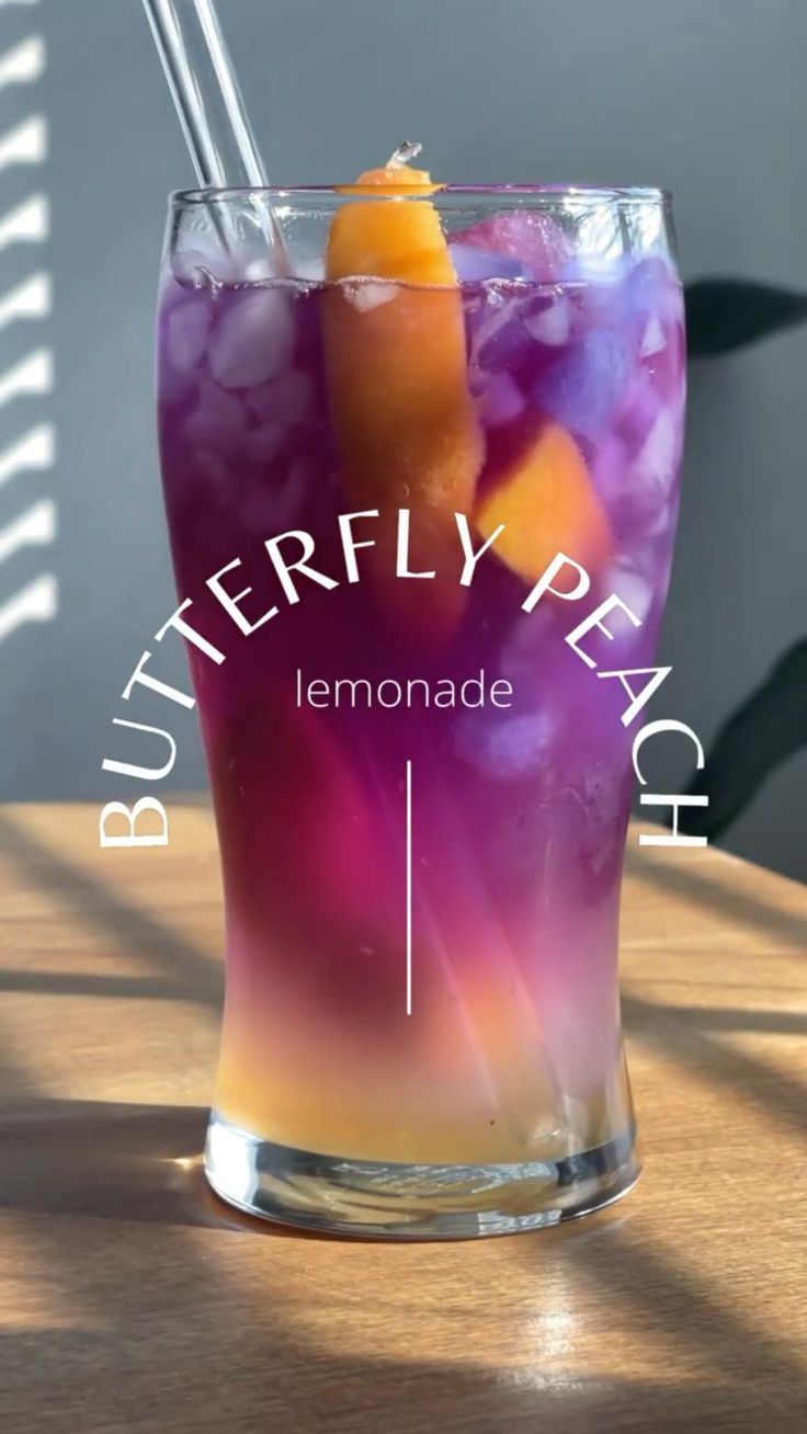 a purple drink with an orange slice in it