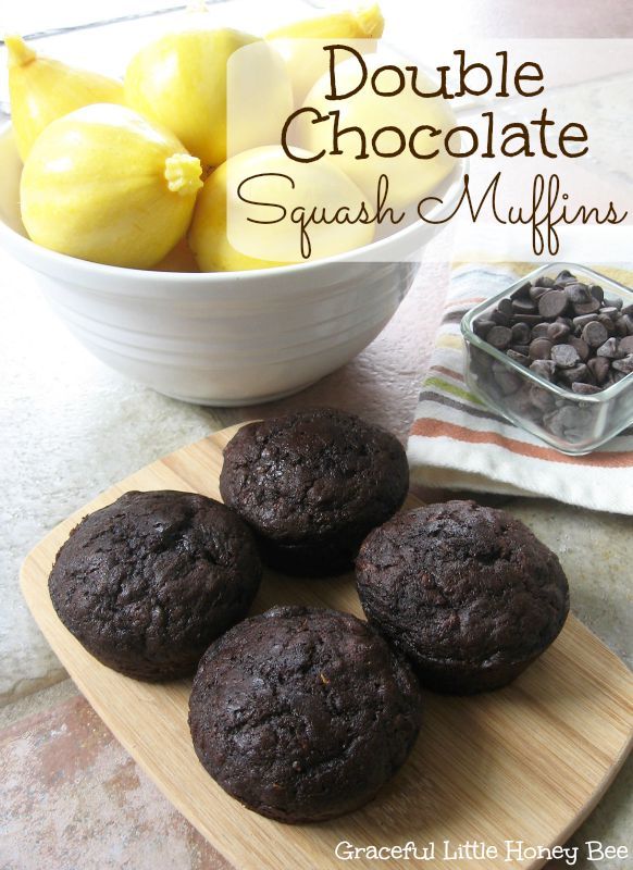 four chocolate muffins on a cutting board next to a bowl of lemons