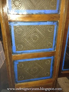 an old wooden door with blue paint on the glass and wood trimming around it