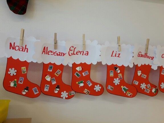 christmas stockings hanging on clothes pins with name and pictures attached to the stocking holders