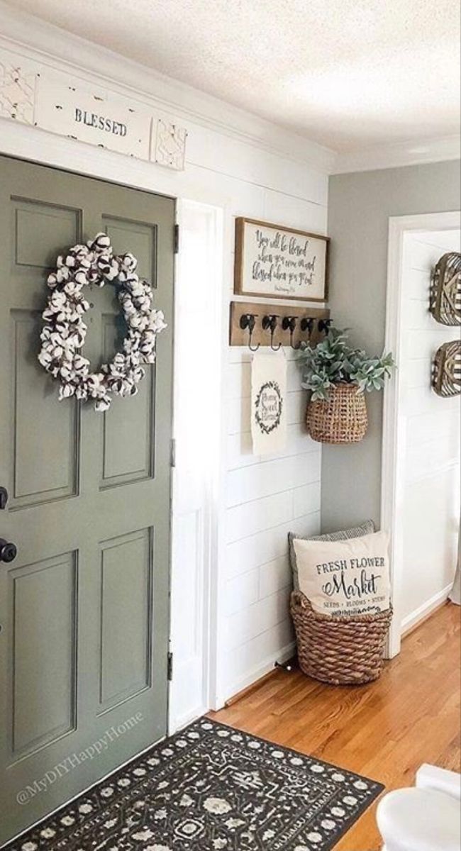 a door with a wreath on it and some baskets hanging from the wall next to it