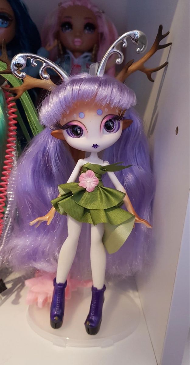 there is a doll with purple hair and deer antlers on it's head