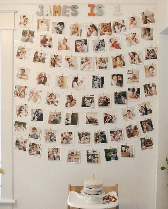 a white wall covered in pictures and photos next to a table with a cake on it