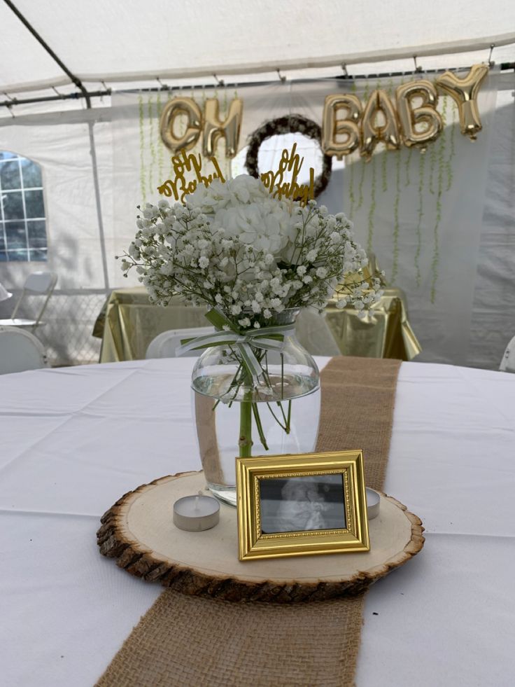 a vase filled with baby's breath flowers on top of a white table cloth