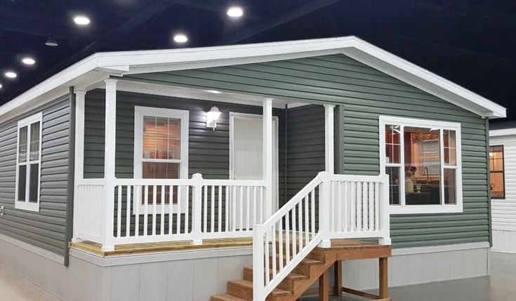 a mobile home with stairs leading up to the front door and second story on display