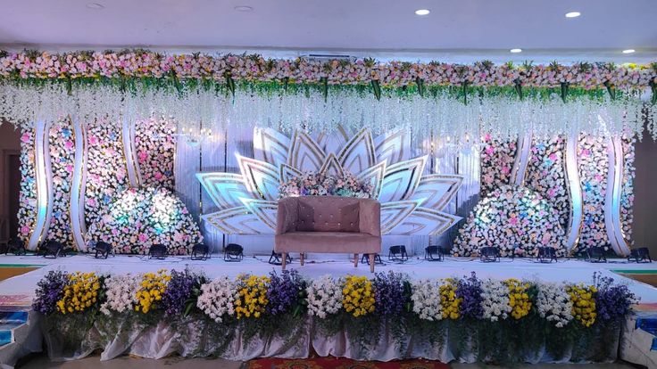 an elaborate stage set up with flowers and chairs