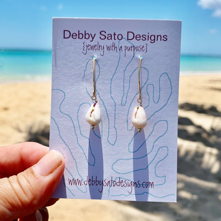 Perfect for the ocean lover in your life, these earrings feature petite cone shells. The length from the top of the earwire are about 1⅜" Pairs with our matches our Petite Cone Shell Necklace Available in Sterling Silver and Gold Fill The shells and beach glass we use are collected in Hawai`i. All our shells are never collected "live". These are natural Shells which means there will be variations in color, shape, and surface. A portion of all sales go to organizations that protect native Hawaiia Adjustable Shell Earrings With Ocean-inspired Style, Adjustable Shell Earrings, Ocean-inspired, White Dangle Beachy Jewelry, White Earrings With Ear Wire For Vacation, White Ear Wire Earrings For Vacation, Ocean-inspired Shell Earrings For Gifts, Unique Nickel-free Earrings For Beach, Nickel Free White Jewelry For Vacation, Handmade Ocean-inspired Pearl Earrings For Gift