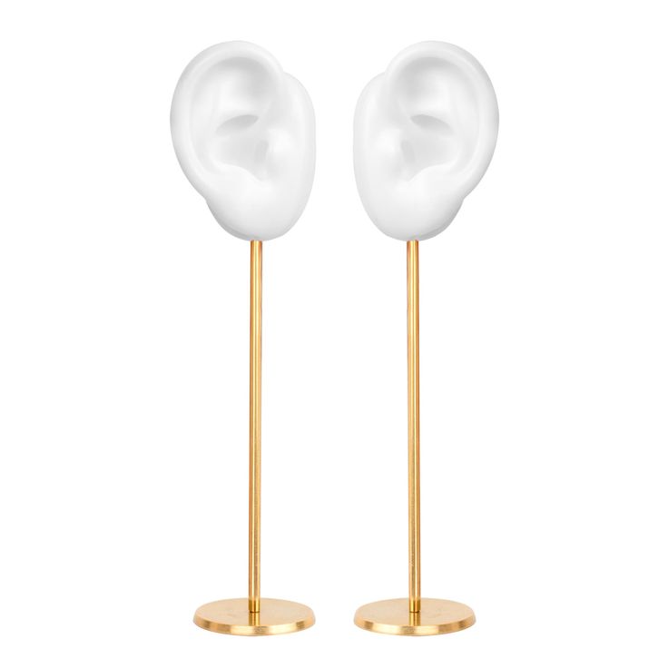 two gold and white ear stands on top of each other