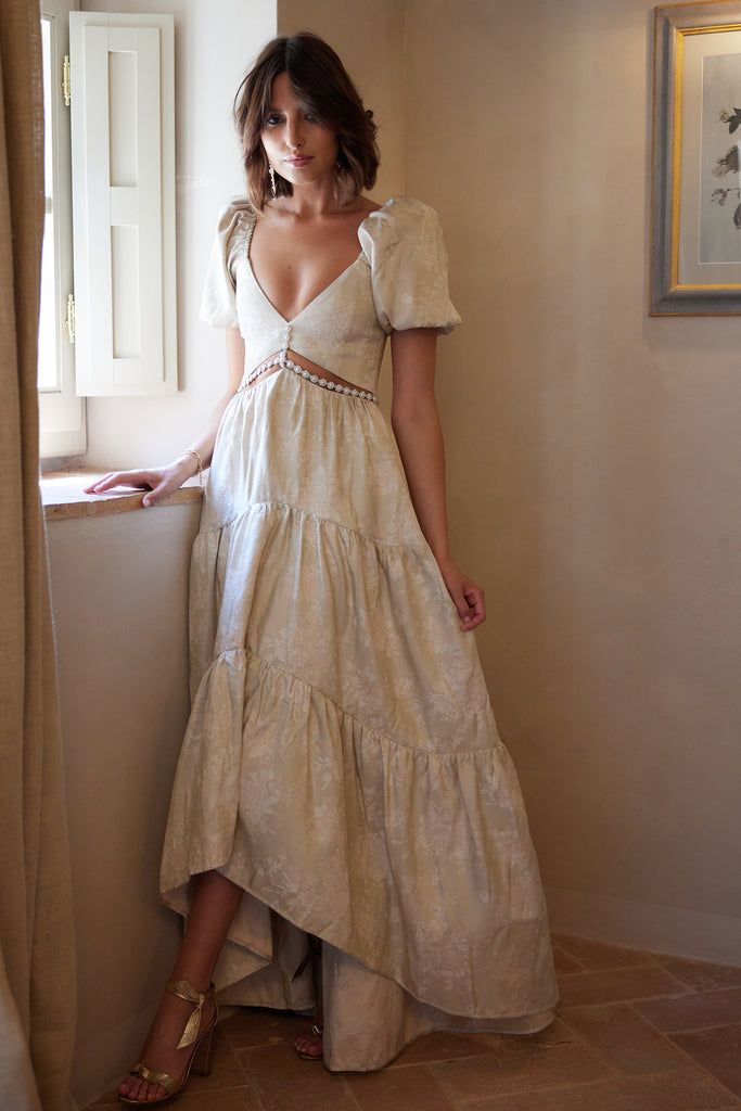 a woman standing next to a window in a white dress