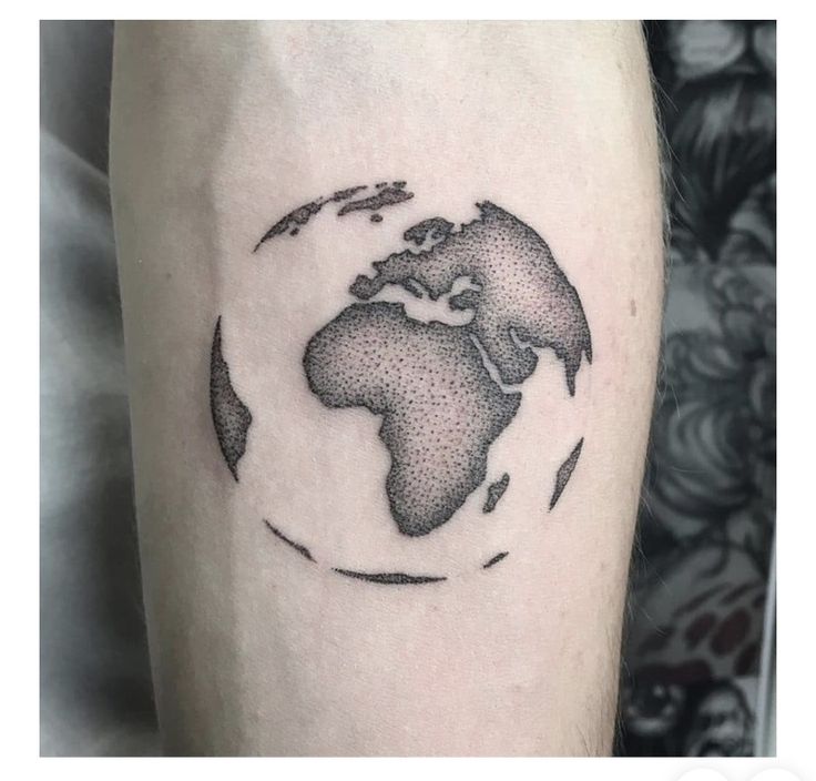 a black and white photo of the world on someone's arm