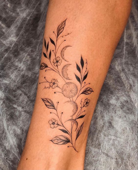 a woman's foot with flowers and leaves tattoo on the side of her leg