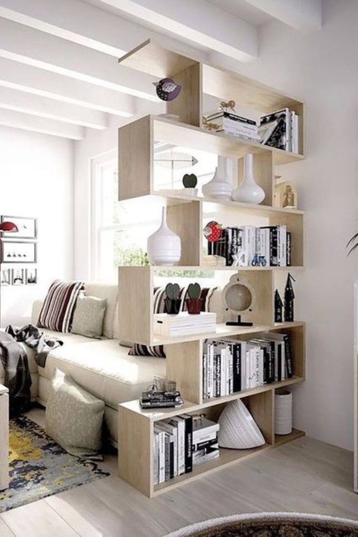 a living room filled with lots of furniture and bookshelves next to a window