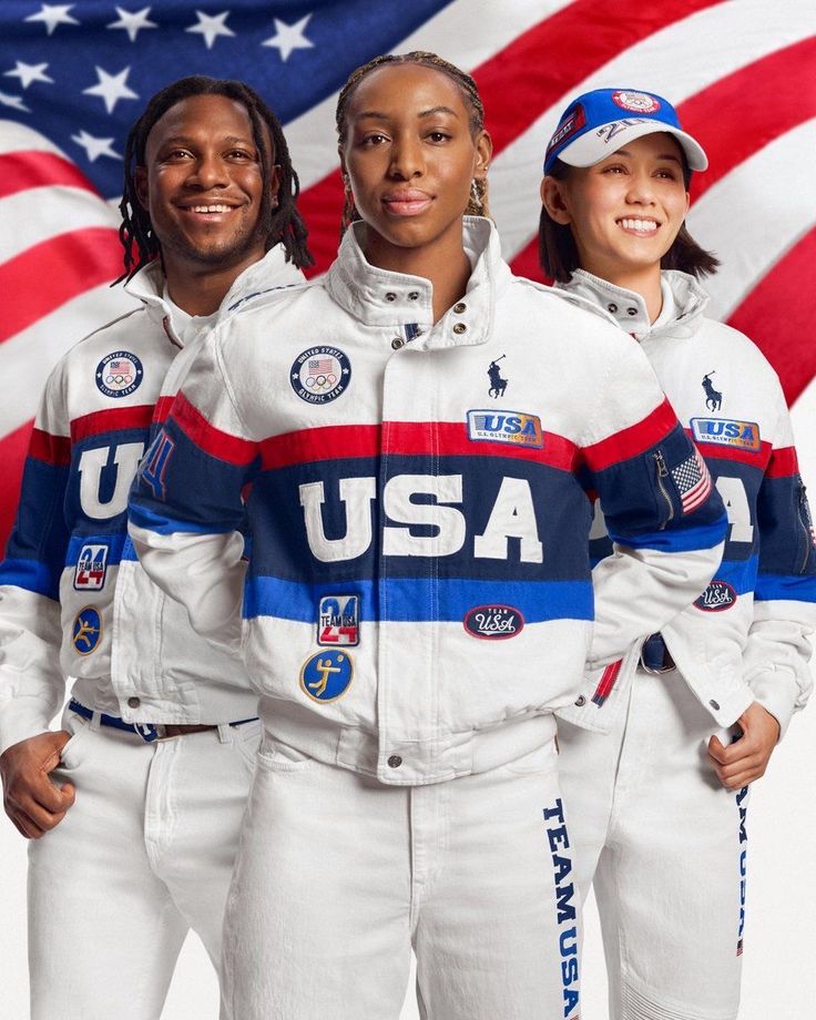 two men and a woman in white space suits standing next to each other with an american flag behind them