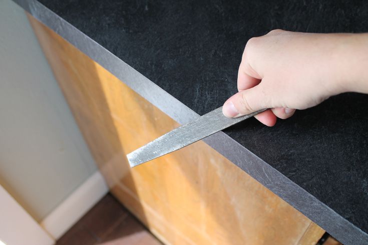 a person holding a knife on top of a counter