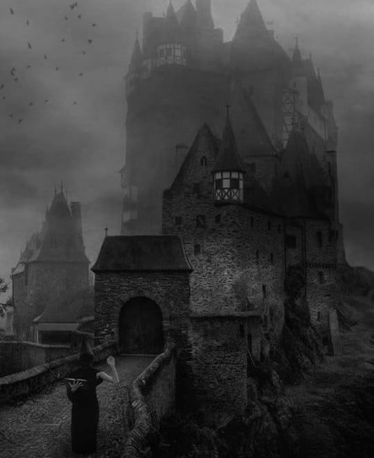 a man standing in front of an old castle on a hill with birds flying around