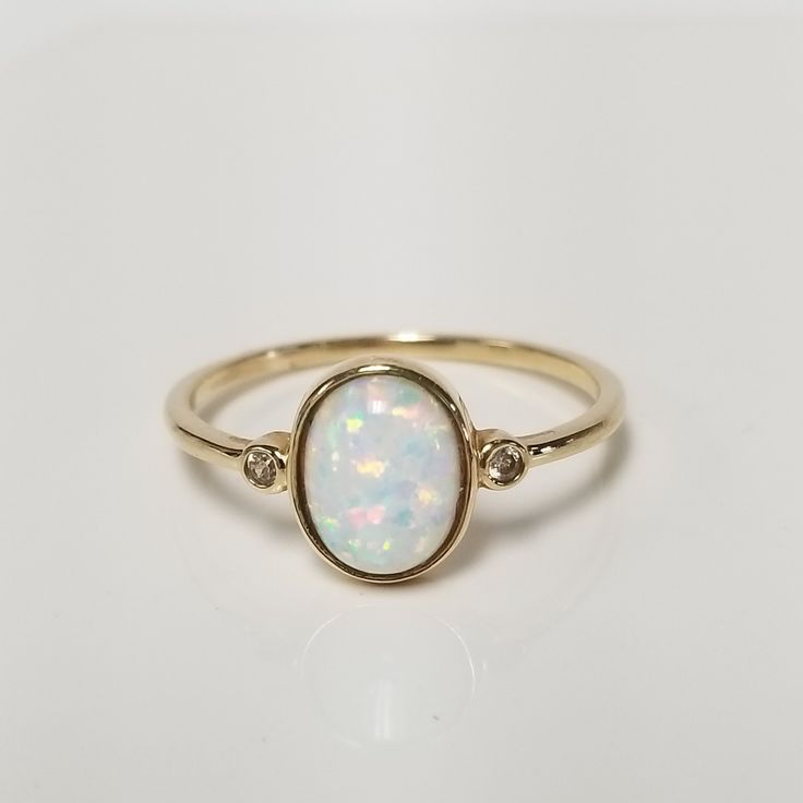 Thanks for shopping our vintage estate store. We tend to sell well below wholesale and truly hope you enjoy all of our items. Many of the items are one of a kind, so please enjoy scrolling through the pictures and hopefully something will catch your eye. Spots are from the camera or reflections. Estate 14k yellow gold created blue 1ct opal .02ct cz diamond cocktail ring.  Just stunning.  Ring size: 10 Setting: 3/8" 10mm Band width: 1.5mm Weight: 1.37 grams You will love this ring. Marked 14k. Op Classic Opal Ring With Diamond Accents, Classic Oval Opal Ring With Diamond Accents, Heirloom Oval Opal Ring With Diamond Accents, Heirloom Opal Ring With Diamond In Oval Shape, Heirloom Diamond Opal Ring Oval Shaped, Classic Oval Opal Ring With Bezel Setting, Classic Oval Bezel Set Opal Ring, Classic Round Cut Opal Birthstone Ring, Formal Oval Opal Ring With Diamond Accents