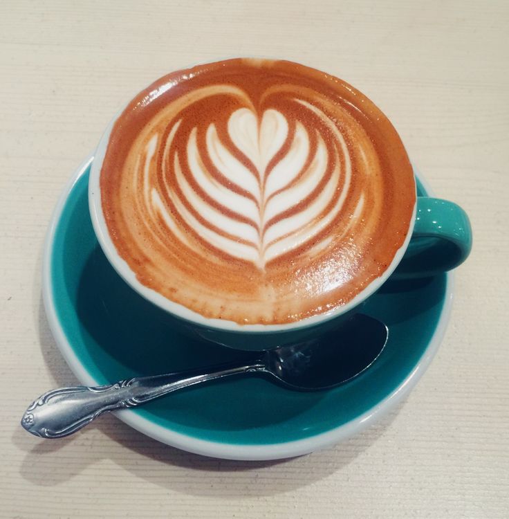 a cappuccino on a saucer with a spoon