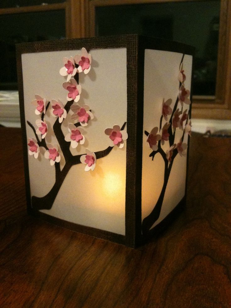 a paper lantern with flowers on it sitting on a table