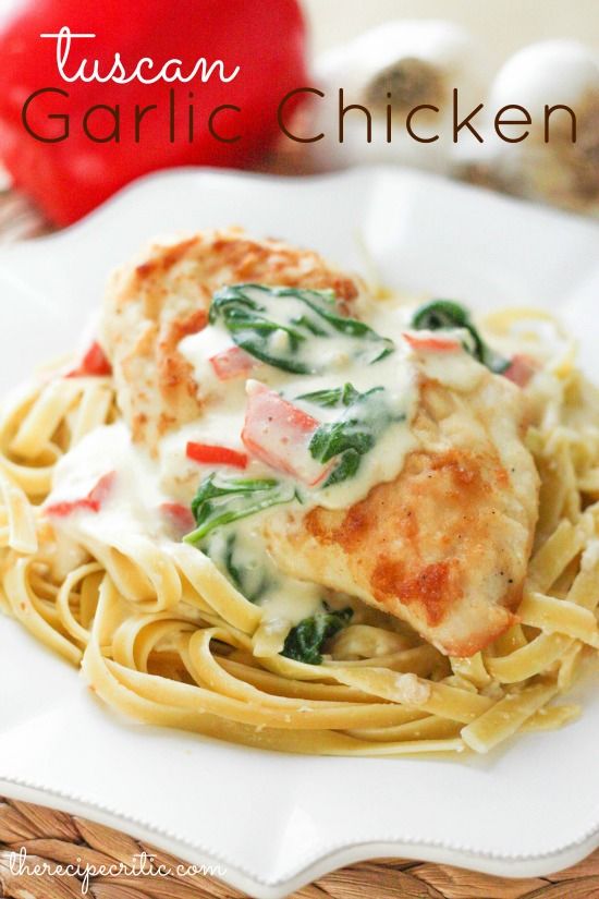 chicken parmesan with spinach and cheese is on a white plate next to some tomatoes