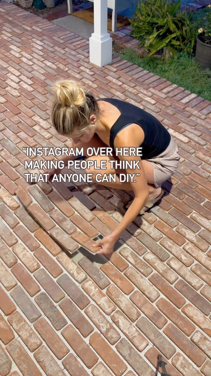 a woman kneeling down on top of a brick floor next to a white post with the words instagram over here making people think that anyone can diy