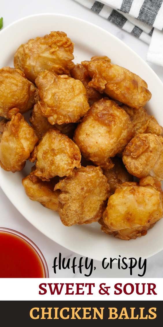 a white plate topped with fried chicken balls next to ketchup and sauce on a table