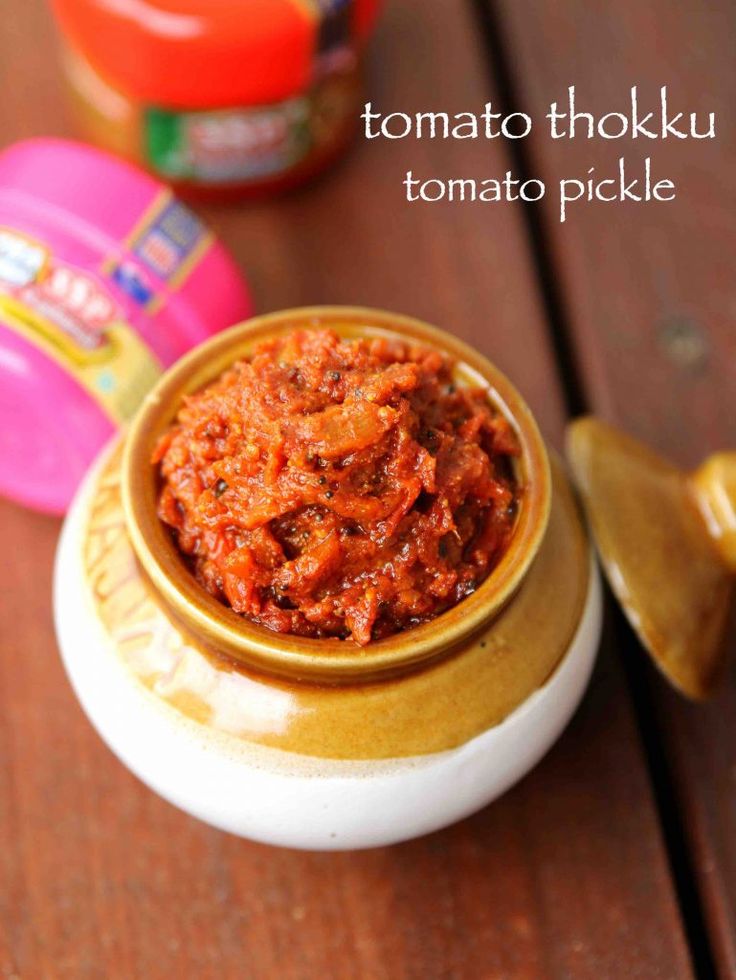 tomato pickle in a small bowl on a wooden table next to other food items