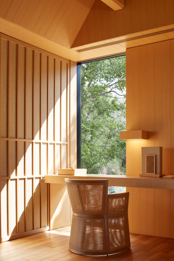 a room with wood paneling and a round table in front of a large window